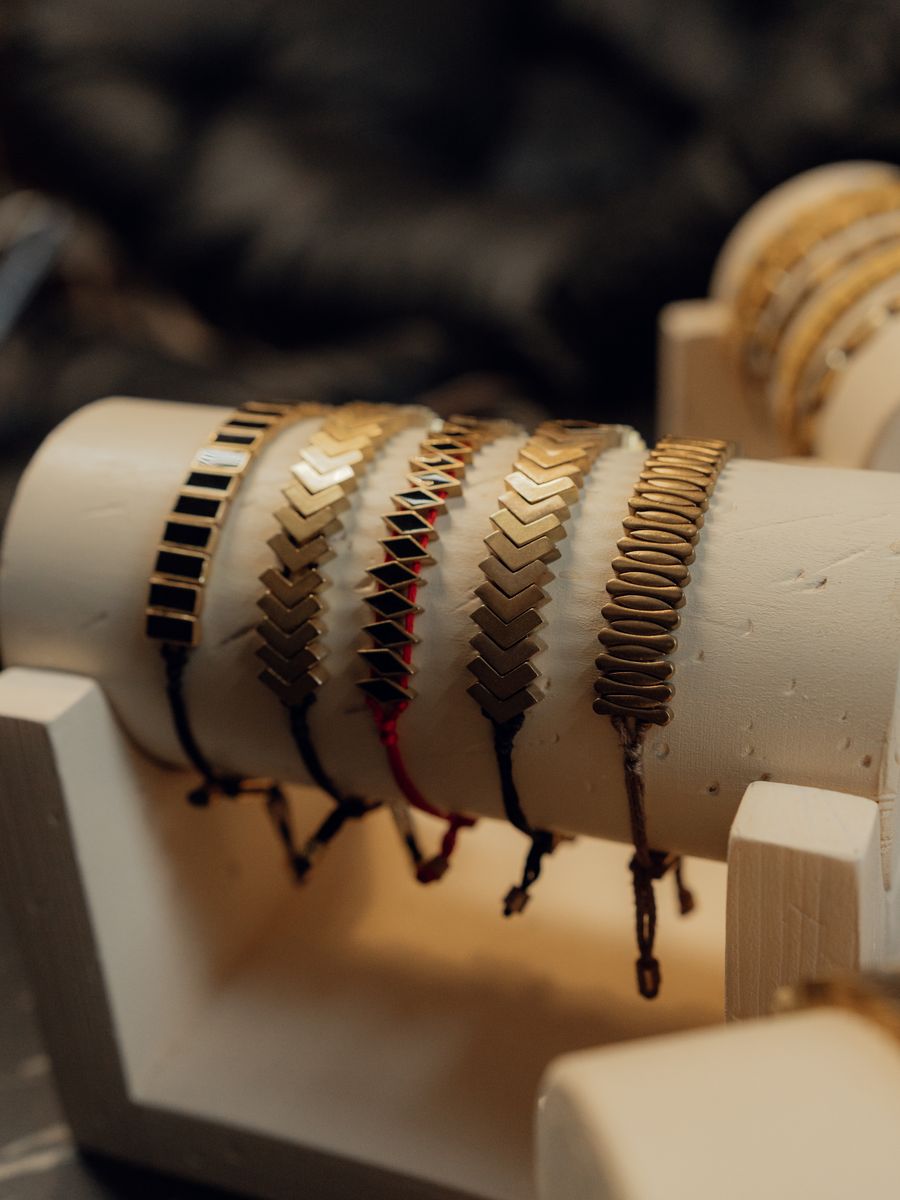 Pulseiras douradas expostas em suporte de joalheria
